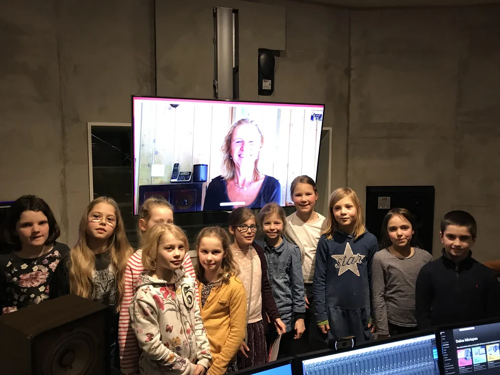 Kindergruppe in einem Tonstudio vor einem Bildschirm bei einer Hörspielproduktion