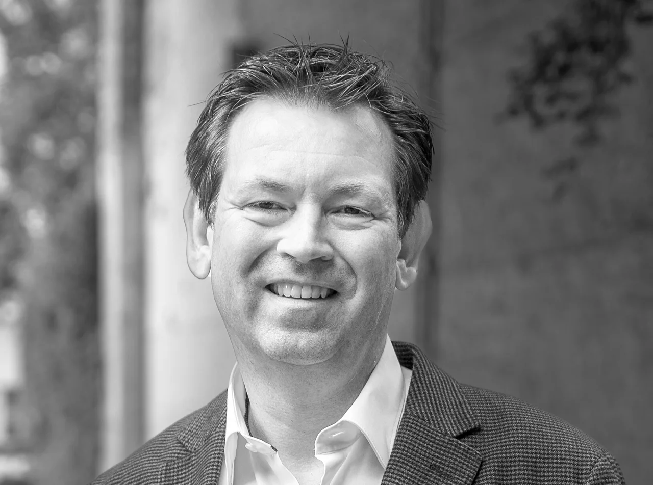 Michael Tschiggerl, lächelndes Porträt im Sakko